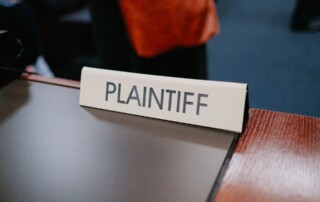 a sign on a desk in a courtroom that says plaintiff on it